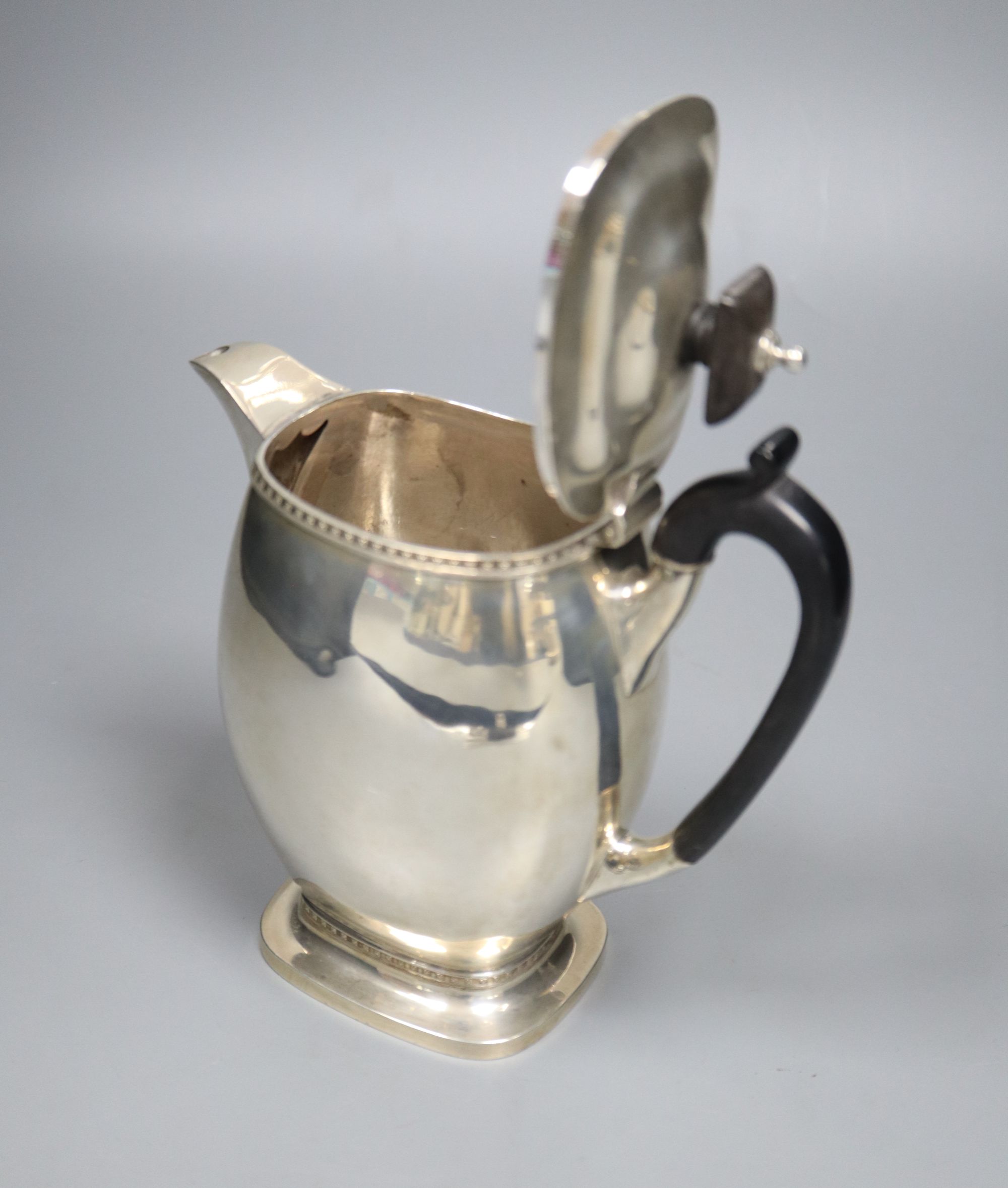 A George V silver hot water pot, with ebonised handle, Carrington & Co, London, 1912, 18.1cm, 16oz.